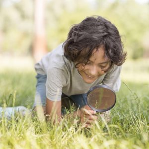 little boy with magnifier outdoor